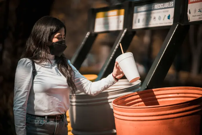a woman wearing a face mask and holding a cup
